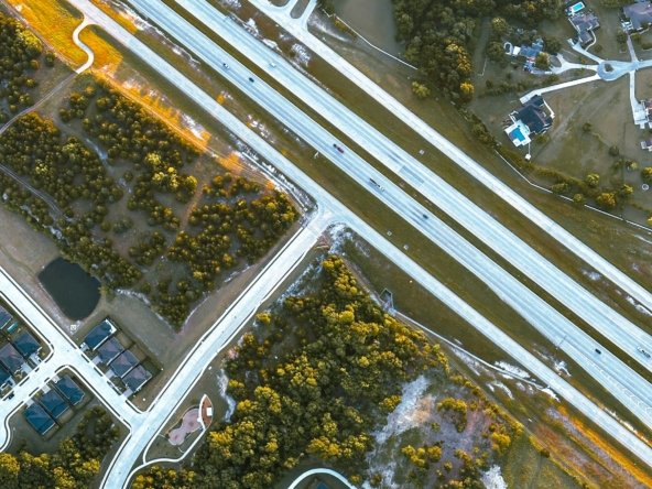 Aerial view of a suburban Texas neighborhood with single-family homes near a highway